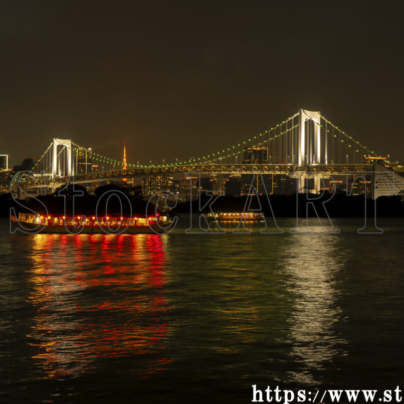 レインボーブリッジの夜景と東京湾をゆく屋形船の灯り